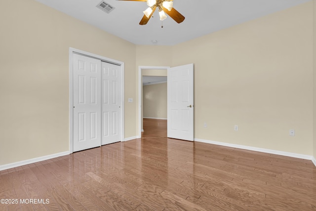 unfurnished bedroom featuring hardwood / wood-style flooring, ceiling fan, and a closet