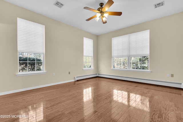 spare room featuring hardwood / wood-style flooring, ceiling fan, and baseboard heating