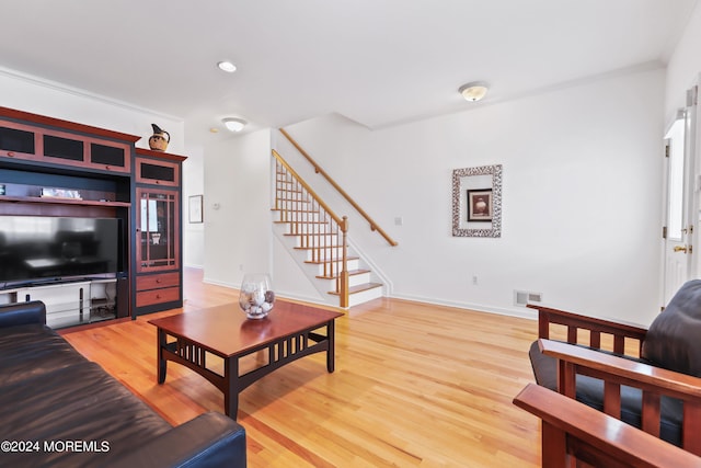 living room with hardwood / wood-style flooring and ornamental molding