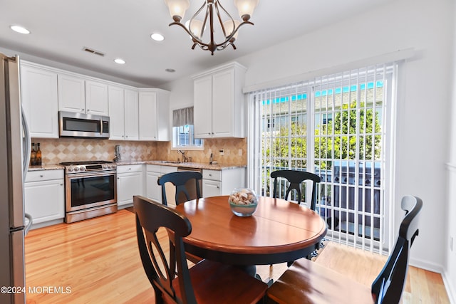 dining area featuring a chandelier, light hardwood / wood-style floors, and sink