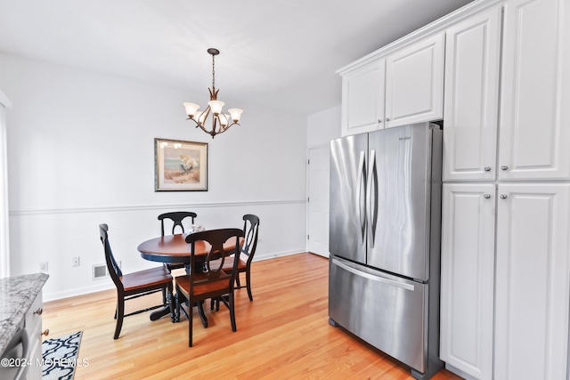 dining room with an inviting chandelier and light hardwood / wood-style floors