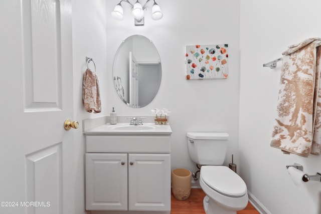 bathroom with vanity, toilet, and wood-type flooring