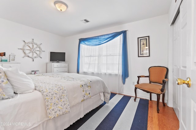 bedroom with hardwood / wood-style floors and a closet