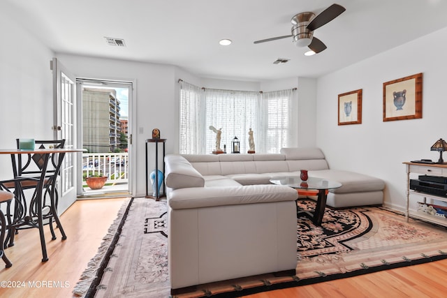 living room with ceiling fan and light hardwood / wood-style flooring