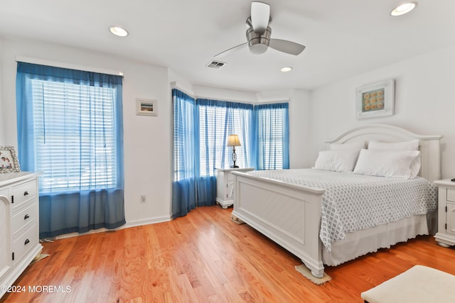 bedroom with ceiling fan, light hardwood / wood-style floors, and multiple windows