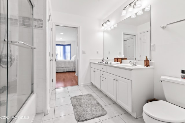 full bathroom featuring vanity, tile patterned floors, shower / bath combination with glass door, and toilet