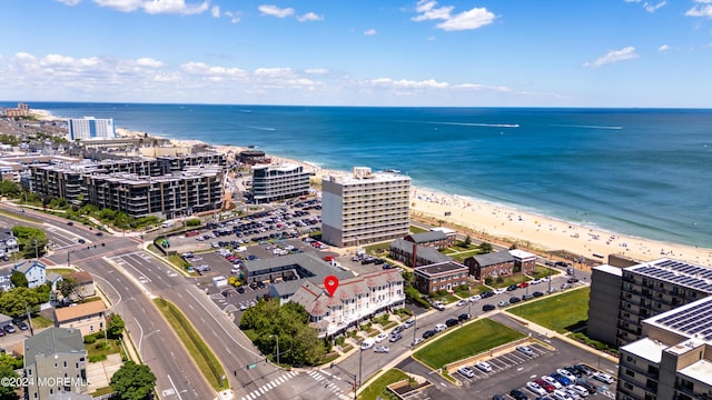 drone / aerial view featuring a water view and a beach view