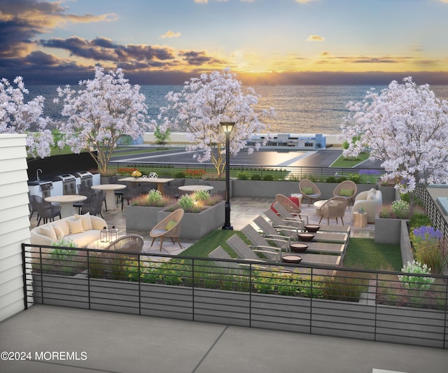 balcony at dusk with a patio area, an outdoor hangout area, and a water view