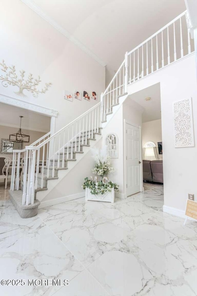 stairway with ornamental molding and a high ceiling