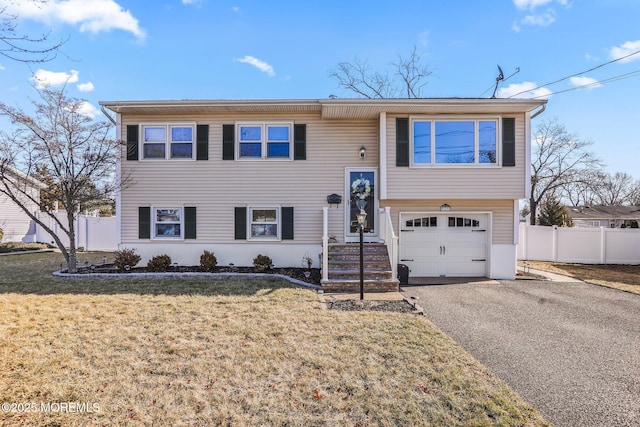 bi-level home featuring a garage and a front yard