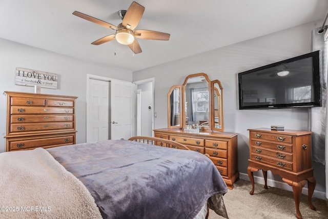 carpeted bedroom with ceiling fan and a closet