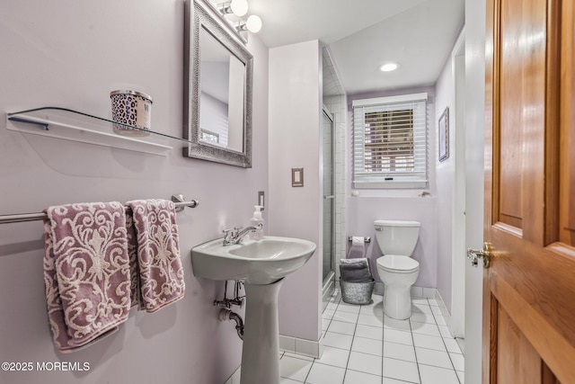 bathroom featuring tile patterned flooring, a shower with door, and toilet