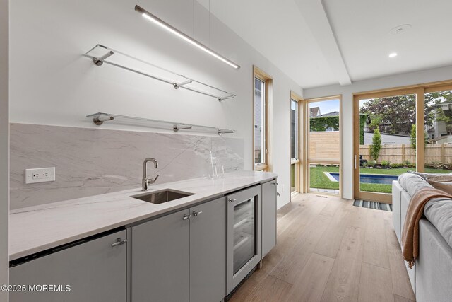 402 Fifth Ave, Asbury Park, NJ 07712 - kitchen featuring a sink, wine cooler, tasteful backsplash, gray cabinetry, and light wood-type flooring