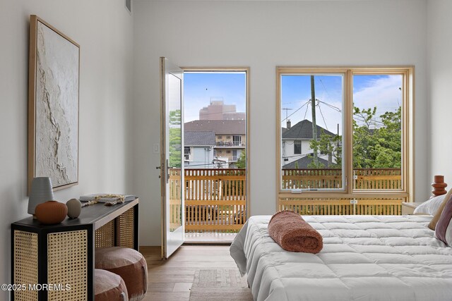 402 Fifth Ave, Asbury Park, NJ 07712 - bedroom featuring wood finished floors, multiple windows, and access to outside