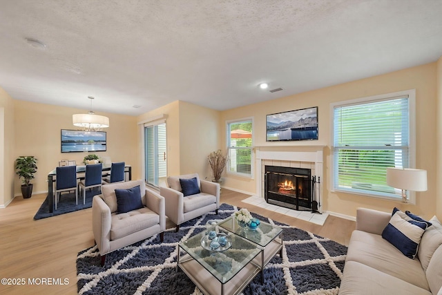90 Van Liew Ct, East Brunswick, NJ 08816 - living room with light wood finished floors, a tiled fireplace, and a textured ceiling