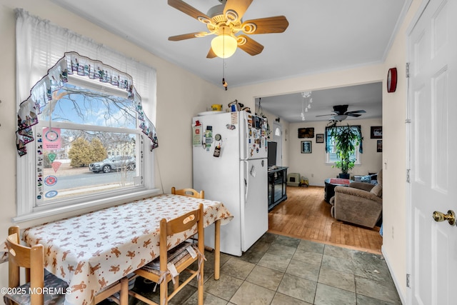 kitchen featuring freestanding refrigerator, a healthy amount of sunlight, ceiling fan, and light tile patterned floors