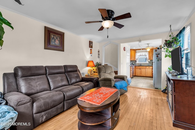 living area featuring a ceiling fan and light wood finished floors