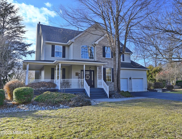 view of front of property with a porch, a garage, and a front lawn