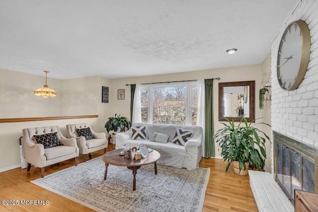 living room featuring wood-type flooring, a fireplace, and a textured ceiling