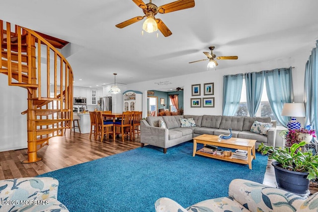 living room featuring wood-type flooring and ceiling fan