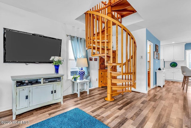 stairs with hardwood / wood-style flooring and a healthy amount of sunlight