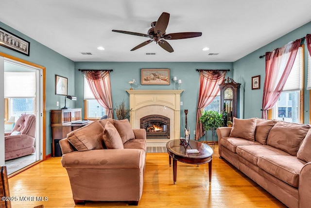 living room featuring ceiling fan, a wealth of natural light, and light wood-type flooring