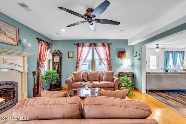 living room with ceiling fan and light wood-type flooring