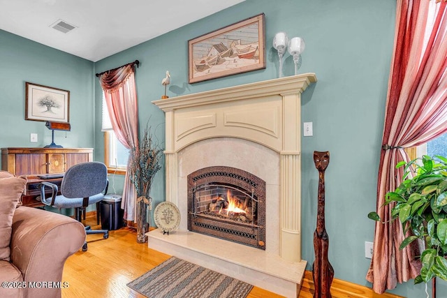 living area with a premium fireplace and light wood-type flooring