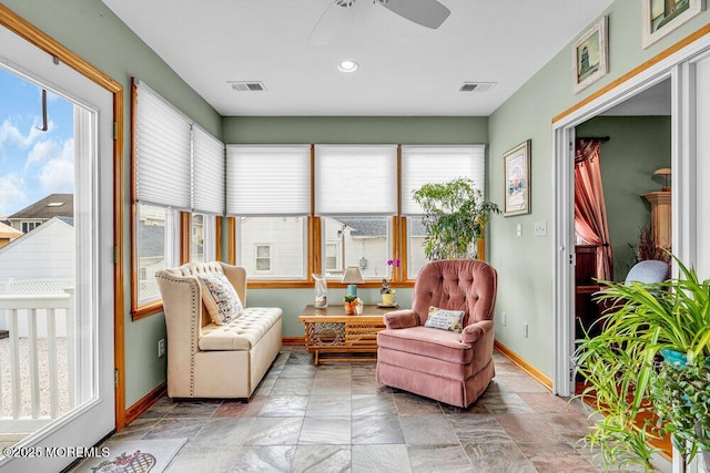 sunroom / solarium featuring plenty of natural light and ceiling fan