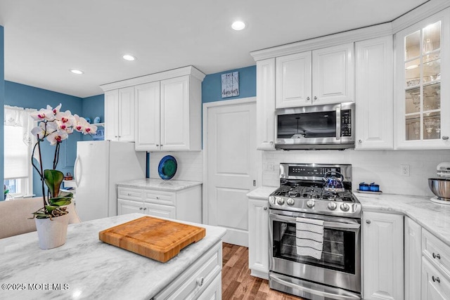 kitchen featuring white cabinetry, tasteful backsplash, stainless steel appliances, and light wood-type flooring