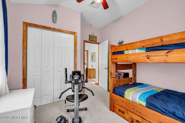 carpeted bedroom with ceiling fan, lofted ceiling, and a closet