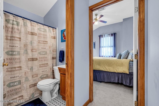 bathroom with toilet, a shower with curtain, vaulted ceiling, vanity, and ceiling fan