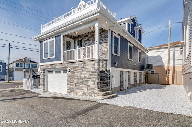 view of front facade with central AC, a balcony, and a garage