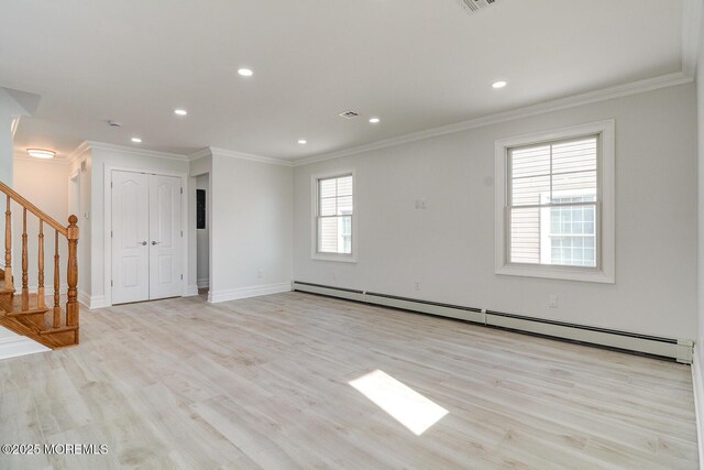 empty room with ornamental molding, light hardwood / wood-style flooring, and a baseboard heating unit