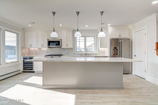 kitchen with wine cooler, stainless steel appliances, a center island, and white cabinets