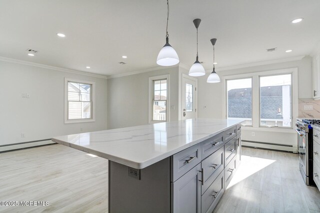 kitchen with high end range, a center island, hanging light fixtures, and light hardwood / wood-style flooring