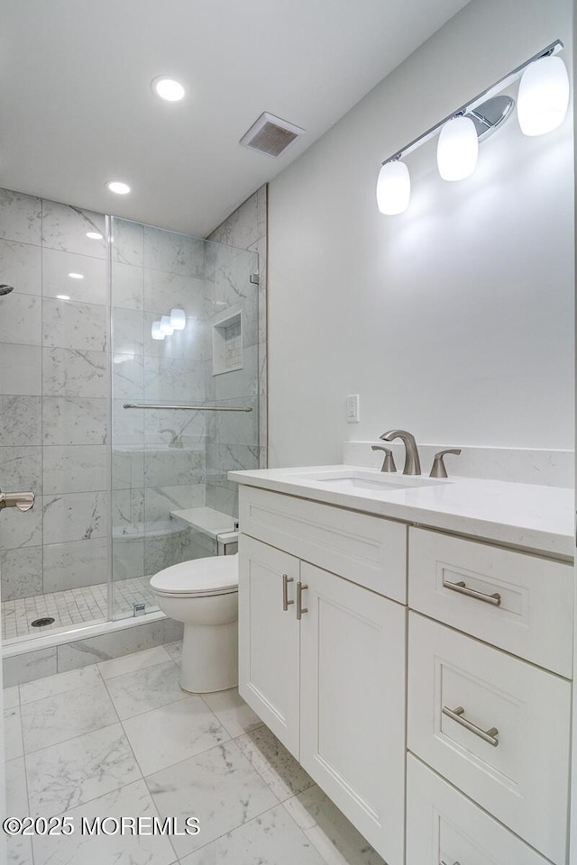 bathroom with vanity, an enclosed shower, and toilet