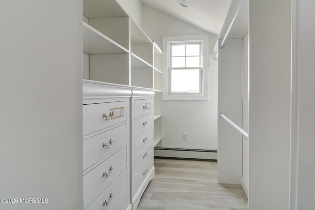 walk in closet with a baseboard heating unit, vaulted ceiling, and light hardwood / wood-style floors