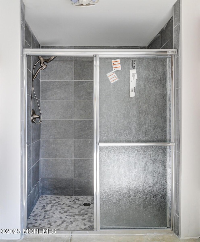 bathroom with a shower with door