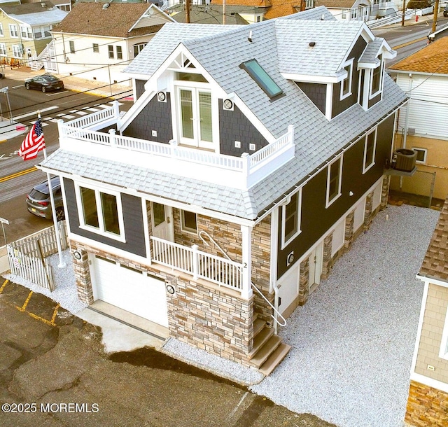 rear view of house with a garage, central AC, and a balcony