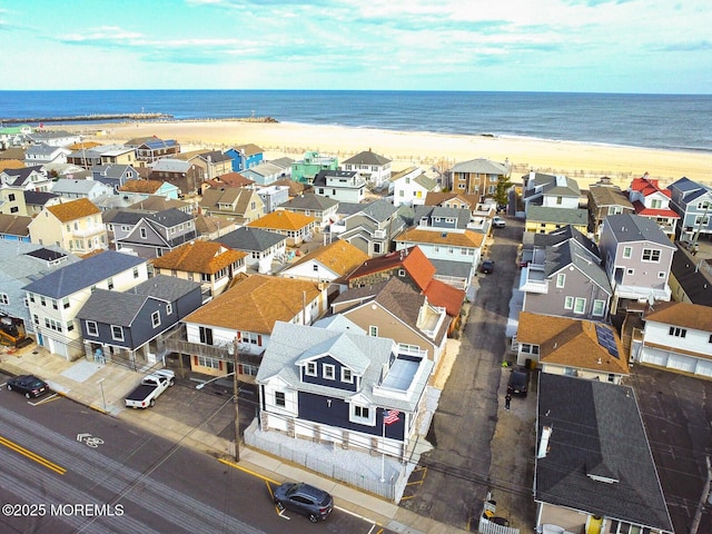 bird's eye view with a water view and a beach view