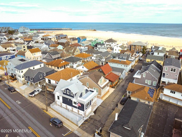 drone / aerial view featuring a water view and a beach view