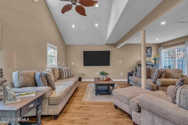 living room with high vaulted ceiling, a wealth of natural light, ceiling fan, and light hardwood / wood-style flooring