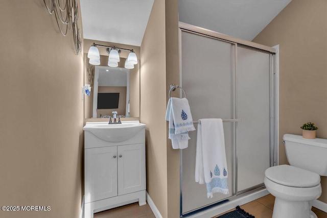 bathroom featuring vanity, a shower with door, and toilet