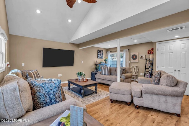 living room with high vaulted ceiling, ceiling fan, and light hardwood / wood-style flooring