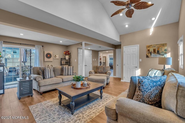 living room with high vaulted ceiling, ceiling fan, and light wood-type flooring