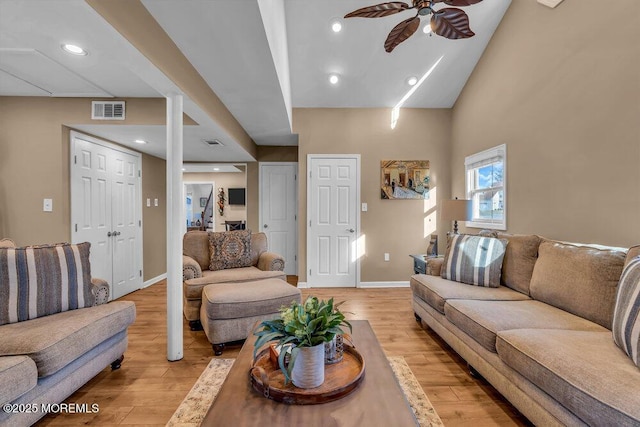 living room with light hardwood / wood-style flooring, high vaulted ceiling, and ceiling fan