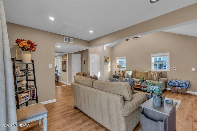 living room featuring vaulted ceiling and light wood-type flooring