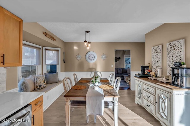 dining space featuring lofted ceiling and light wood-type flooring