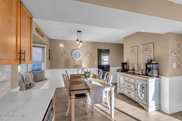 dining space featuring vaulted ceiling and light hardwood / wood-style flooring